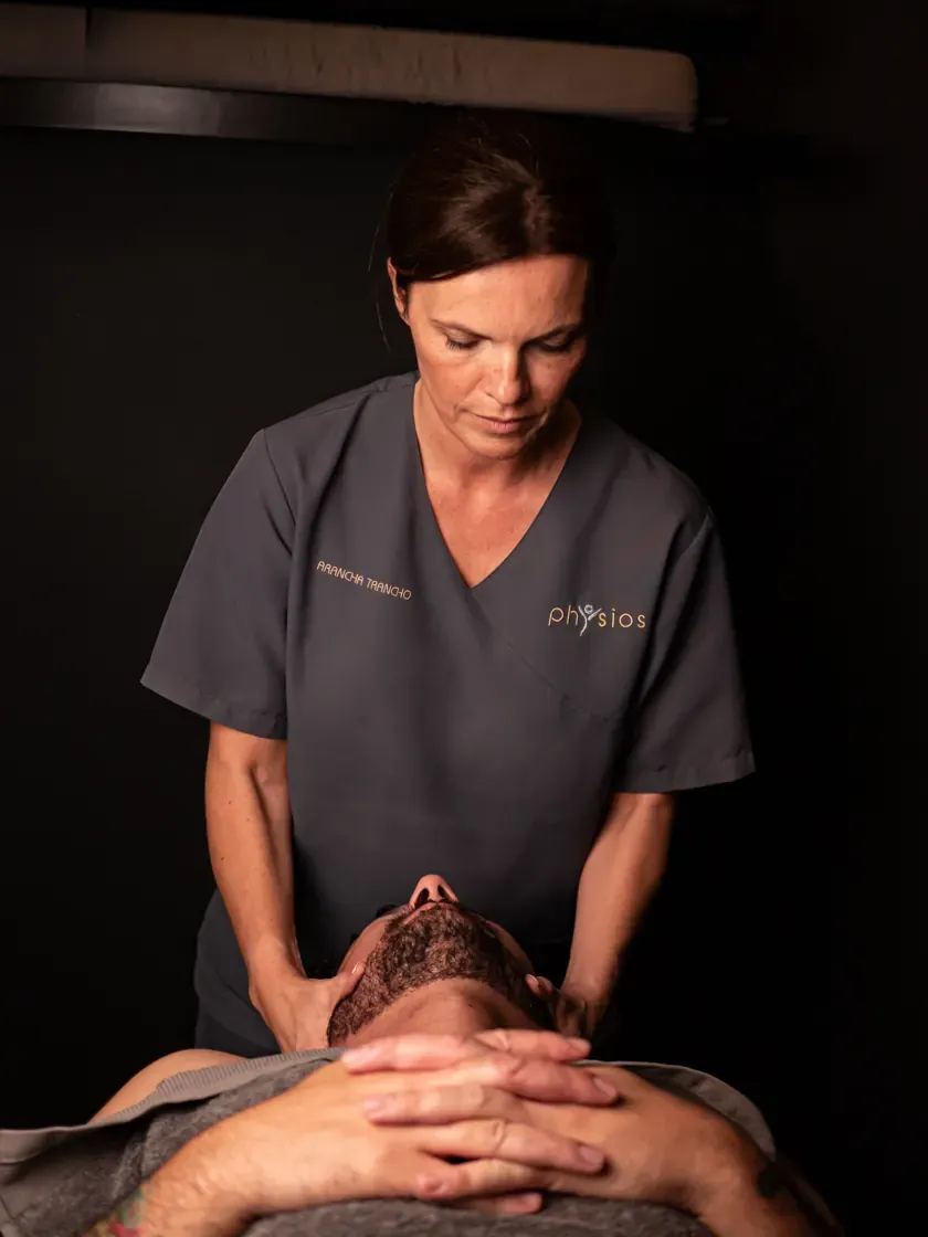 Arancha treating a patient's neck on the treatment table